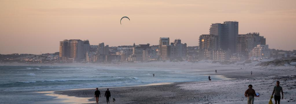 People walk on Sunset Beach at sunset in Cape Town, South Africa, on March 26, 2022. (Xinhua/Lyu Tianran)