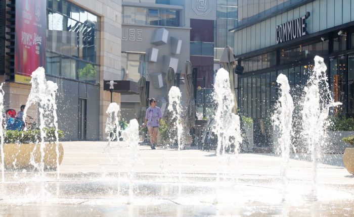 Moradora caminha em meio a uma fonte ante as altas temperaturas no distrito de Minhang, em Shanghai, leste da China, em 10 de julho de 2022. (Xinhua/Fang Zhe)