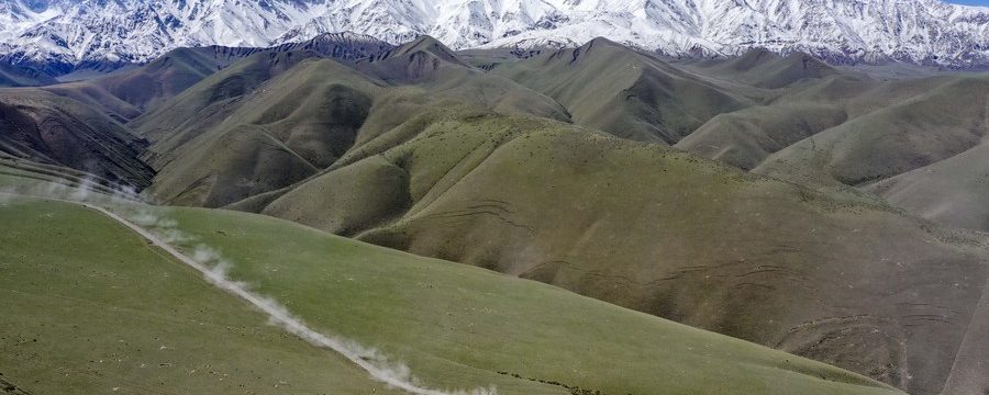 Foto aérea tirada em 31 de maio de 2019 mostra um carro de corrida correndo na pista no sopé norte das montanhas Kunlun, na Região Autônoma Uigur de Xinjiang, noroeste da China. (Xinhua/Hu Huhu)