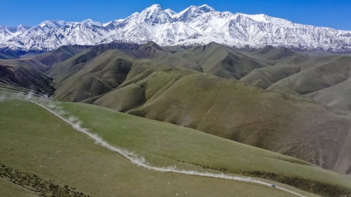 Foto aérea tirada em 31 de maio de 2019 mostra um carro de corrida correndo na pista no sopé norte das montanhas Kunlun, na Região Autônoma Uigur de Xinjiang, noroeste da China. (Xinhua/Hu Huhu)