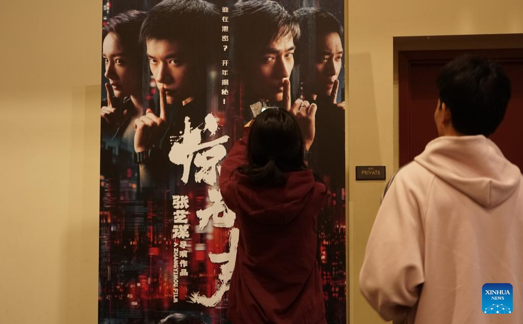 Público observa pôster de "Scare Out", um thriller de espionagem contemporâneo dirigido por Zhang Yimou, em um cinema em Monterey Park, Condado de Los Angeles, Califórnia, Estados Unidos, em 17 de fevereiro de 2026. Vários filmes chineses serão lançados na América do Norte durante o período do Ano Novo Chinês, também conhecido como Festa da Primavera, incluindo dois sucessos de bilheteria muito aguardados que estrearam na terça-feira, o Dia do Ano Novo Lunar Chinês. (Foto de Zeng Hui/Xinhua)