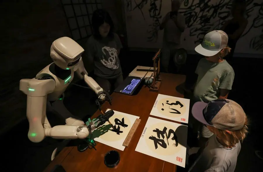 Robótica e games levam tradição chinesa à Bienal de Veneza Visitantes observam a caligrafia robótica no pavilhão da China, com o tema "Dream Stream", na 61ª Exposição Internacional de Arte da Bienal de Veneza, em Veneza, Itália, em 1º de setembro de 2026. (Xinhua/Wang Kaiyan)