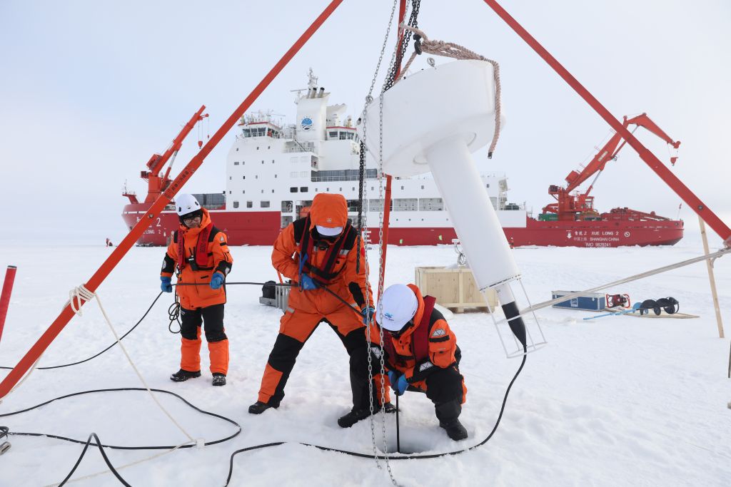 Quebra-gelos chineses Xuelong e Xuelong 2 retornam após expedição ao Ártico Membros da equipe da 16ª expedição científica chinesa ao Oceano Ártico trabalham na superfície de gelo do Oceano Ártico em 9 de agosto de 2026. (Xinhua/Wen Jinghua)