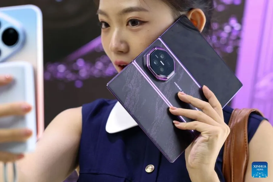 Huawei revela chip de alto desempenho Kirin 9050 Pro Uma pessoa da plateia tira uma selfie com o smartphone de dobra tripla Mate XT 2 da Huawei, equipado com o novo chip Kirin 9050 Pro, após um evento de lançamento em Guangzhou, na província de Guangdong (sul da China), em 7 de setembro de 2026. A gigante chinesa de tecnologia Huawei lançou, na segunda-feira, o smartphone de dobra tripla Mate XT 2, equipado com o novo chip Kirin 9050 Pro — o primeiro processador de alto desempenho a utilizar a tecnologia de dobra lógica. (Xinhua/Mao Siqian)