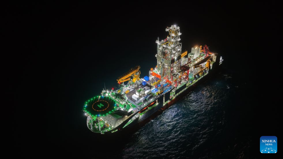Uma foto aérea feita por drone em 28 de julho de 2026 mostra o navio chinês de perfuração oceânica Mengxiang realizando uma operação noturna. O navio chinês Mengxiang estabeleceu um recorde nacional de perfuração em águas profundas, elevando sua capacidade para a marca de 5.000 metros após obter amostras de basalto da bacia do Mar do Sul da China, informou o Ministério de Recursos Naturais na segunda-feira. Isso marca a entrada da China no grupo de elite internacional em termos de capacidade de perfuração em águas profundas, segundo o ministério. (Foto de Zhang Fatao/Xinhua) Uma foto aérea feita por drone em 28 de julho de 2026 mostra o navio chinês de perfuração oceânica Mengxiang realizando uma operação noturna. O navio chinês Mengxiang estabeleceu um recorde nacional de perfuração em águas profundas, elevando sua capacidade para a marca de 5.000 metros após obter amostras de basalto da bacia do Mar do Sul da China, informou o Ministério de Recursos Naturais na segunda-feira. Isso marca a entrada da China no grupo de elite internacional em termos de capacidade de perfuração em águas profundas, segundo o ministério. (Foto de Zhang Fatao/Xinhua)