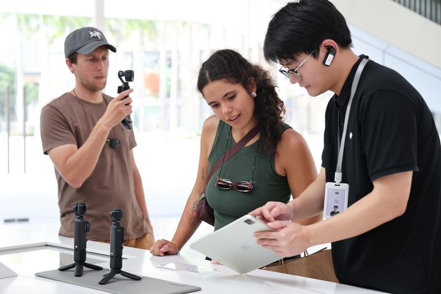 Gastos de turistas estrangeiros na China sobem 28% até julho Turistas estrangeiros compram câmeras portáteis em uma loja-conceito da DJI em Shenzhen, na Província de Guangdong, no sul da China, em 24 de junho de 2026. (Xinhua/Liang Xu)