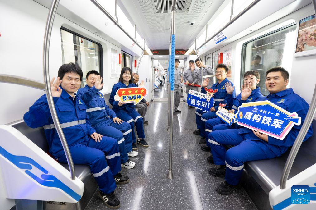 Trabalhadores da construção civil acompanham um trem da Linha 12 do Metrô de Wuhan, em Wuhan, na província de Hubei, centro da China, em 29 de outubro de 2026. (Xinhua/Xiao Yijiu)